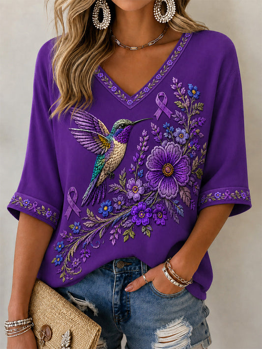 Camiseta feminina com decote em V, estampa floral roxa e beija-flor, de apoio à conscientização sobre a doença de Alzheimer