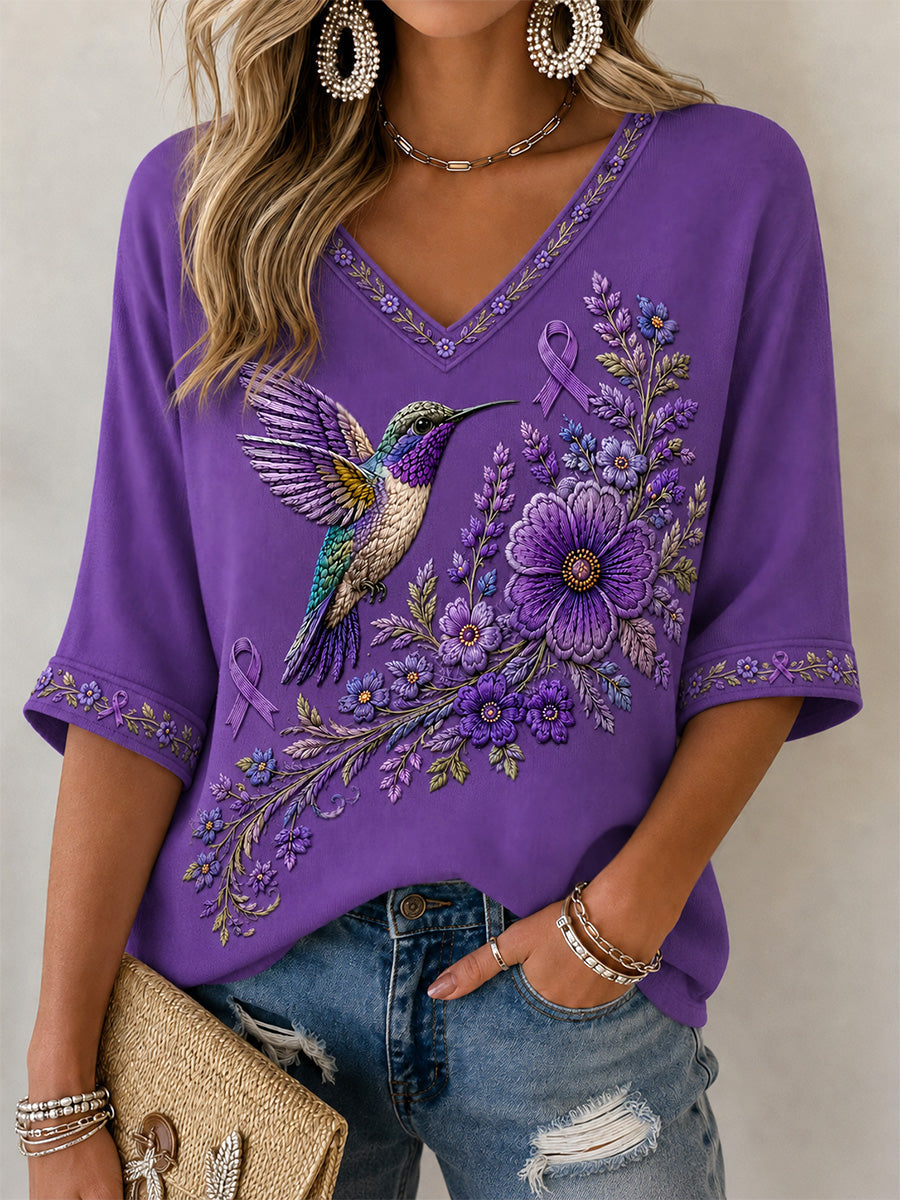Camiseta feminina com decote em V, estampa floral roxa e beija-flor, de apoio à conscientização sobre a doença de Alzheimer