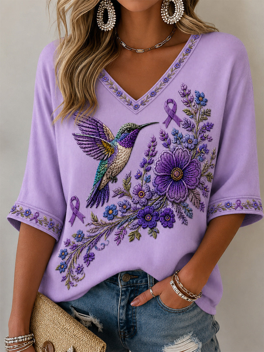 Camiseta feminina com decote em V, estampa floral roxa e beija-flor, de apoio à conscientização sobre a doença de Alzheimer