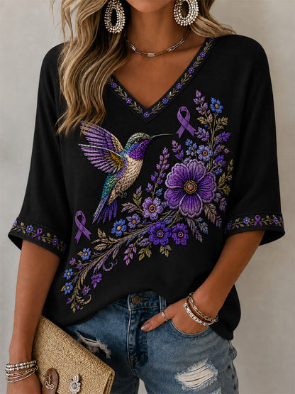 Camiseta feminina com decote em V, estampa floral roxa e beija-flor, de apoio à conscientização sobre a doença de Alzheimer